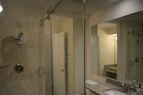 a bathroom with a granite countertop shower and a sink