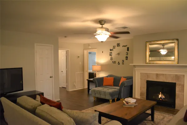 a living room with furniture a fireplace and a flat screen tv