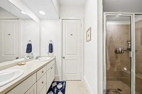 a bathroom with a double vanity sink mirror and shower
