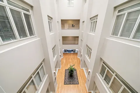 a view of a hallway with wooden floor and stairs