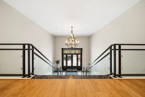 a view of entryway and hall with wooden floor