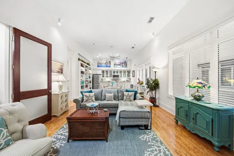 a living room with furniture kitchen view and a large window