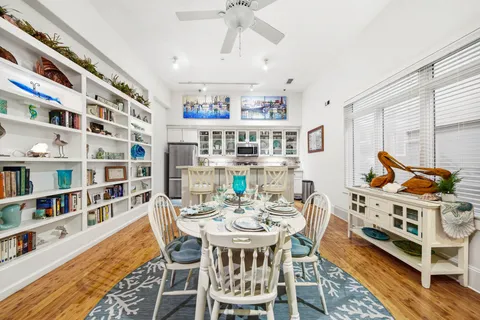 a view of a dining room with furniture a rug and wooden floor