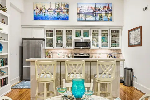 a white kitchen with a stove a sink and a dining table
