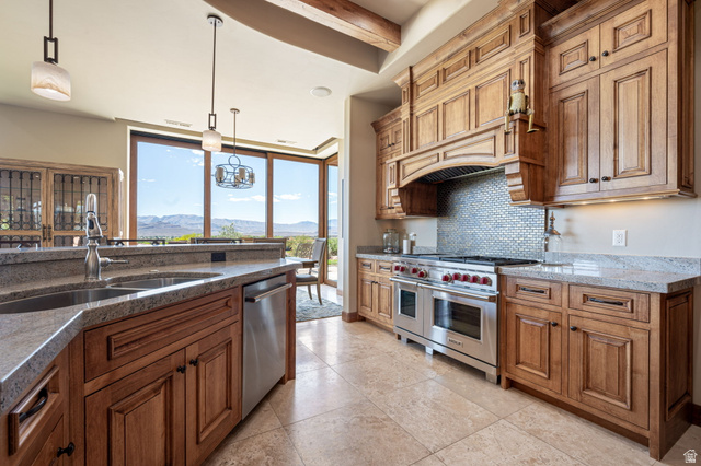2331 West Entrada Trail, Unit 61 St. George, UT 84770 - Photo 15 of 69 Gourmet kitchen featuring custom wood cabinetry, stone countertops, a stainless steel gas range with double ovens, a mosaic tile backsplash, and panoramic windows