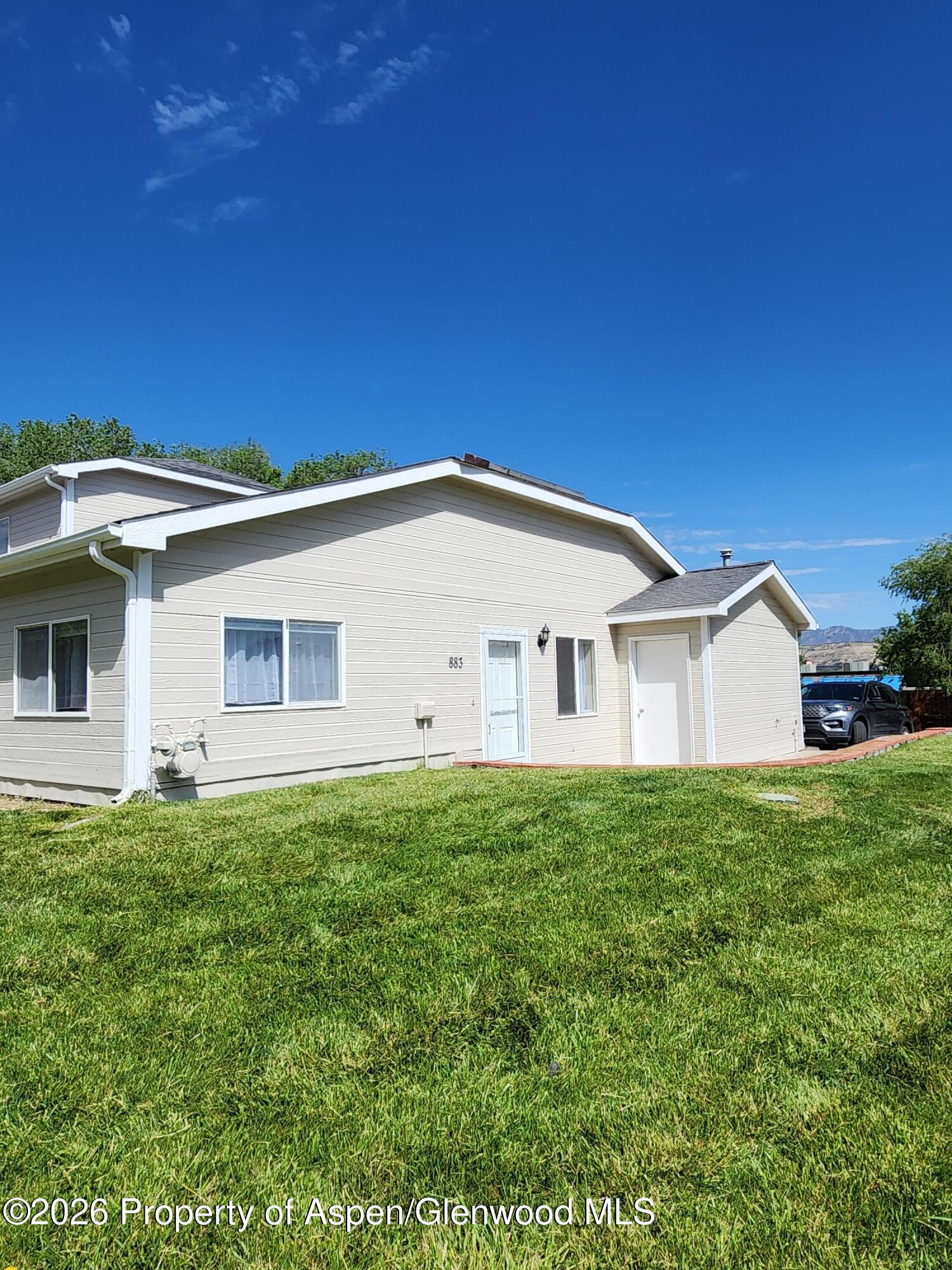 883 Taugenbaugh Boulevard Rifle, CO 81650 - Photo 2 of 18 a view of a house with a yard