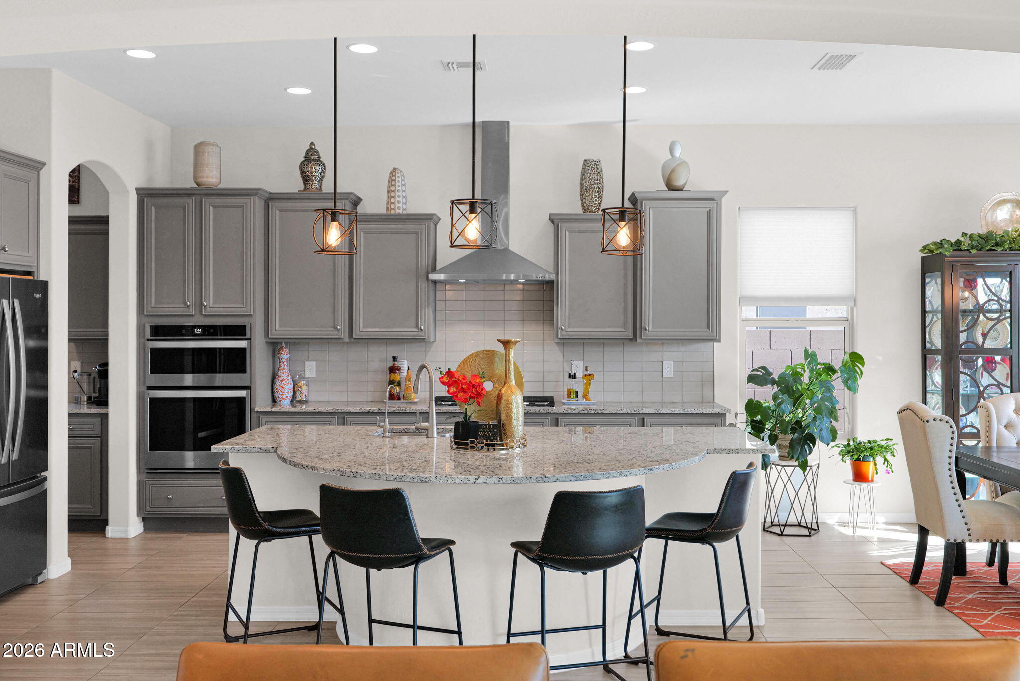 7723 West Willow Way Florence, AZ 85132 - Photo 10 of 64 a kitchen with stainless steel appliances kitchen island granite countertop a dining table chairs and a refrigerator