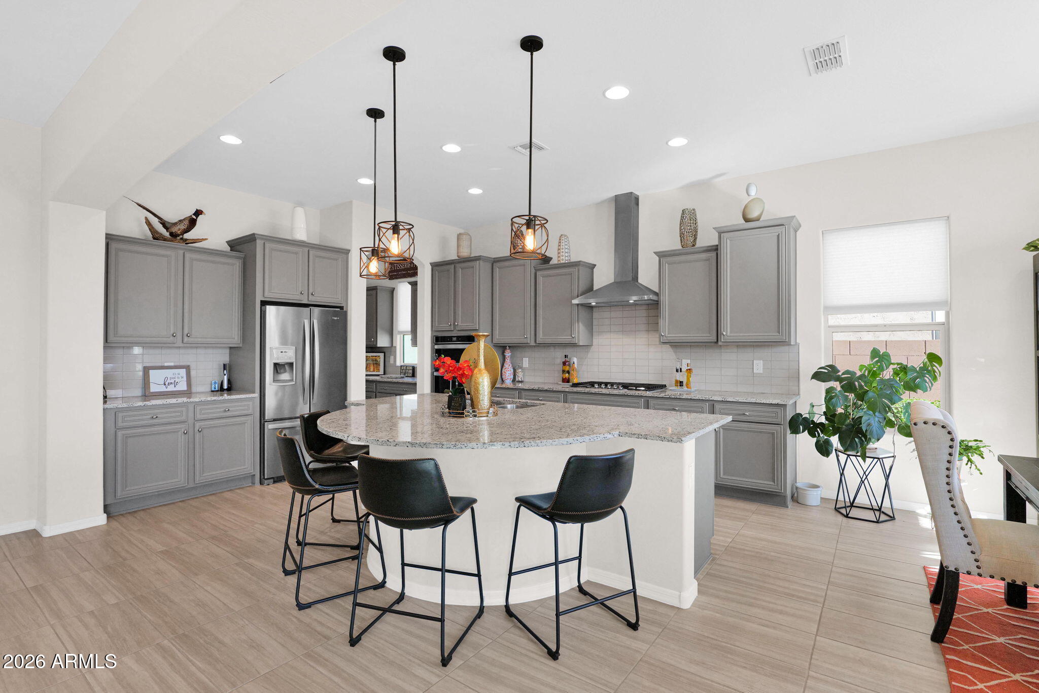 7723 West Willow Way Florence, AZ 85132 - Photo 11 of 64 a kitchen with stainless steel appliances kitchen island granite countertop a dining table chairs and white cabinets