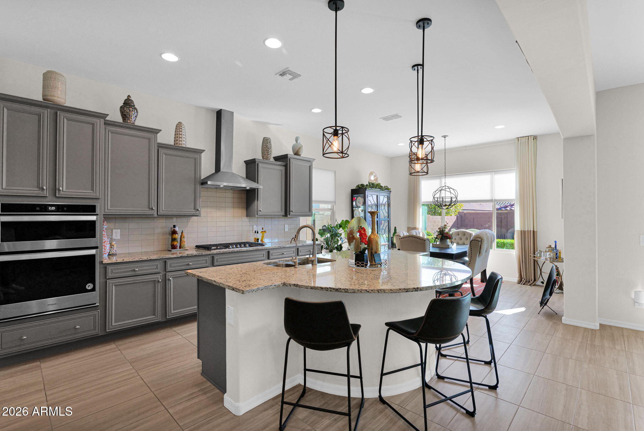 7723 West Willow Way Florence, AZ 85132 - Photo 12 of 64 a kitchen with stainless steel appliances kitchen island a table and chairs in it