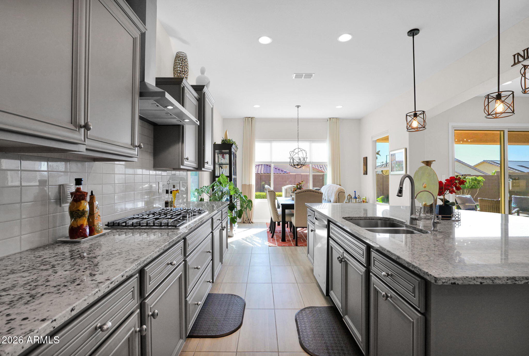 7723 West Willow Way Florence, AZ 85132 - Photo 14 of 64 a kitchen with stainless steel appliances granite countertop a sink a stove and a wooden floors