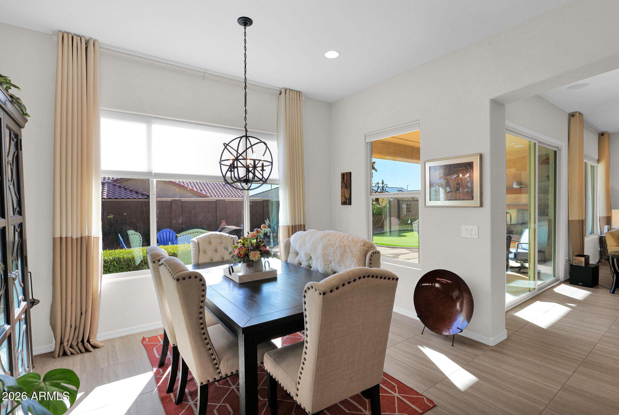 7723 West Willow Way Florence, AZ 85132 - Photo 16 of 64 a dining room with furniture a chandelier and wooden floor