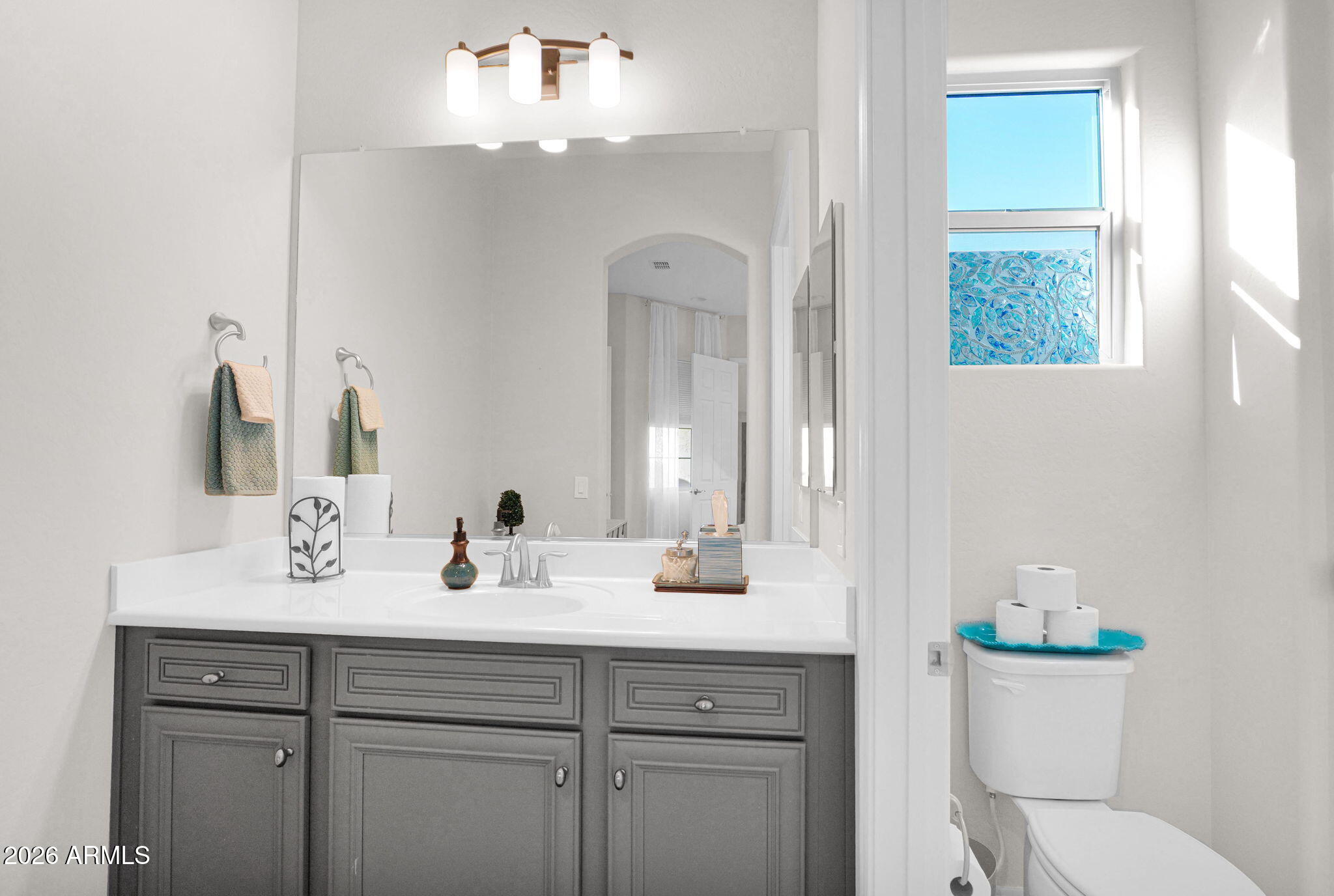 7723 West Willow Way Florence, AZ 85132 - Photo 35 of 64 a bathroom with a toilet a sink a vanity and mirror