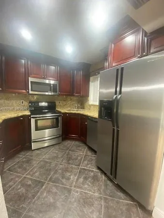 a kitchen with stainless steel appliances granite countertop a refrigerator and a sink