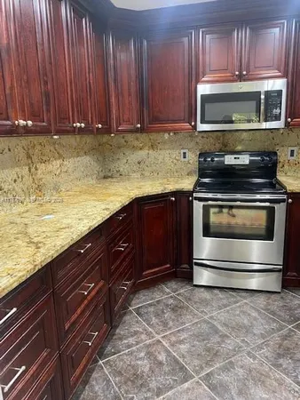 a kitchen with granite countertop a stove and a microwave oven