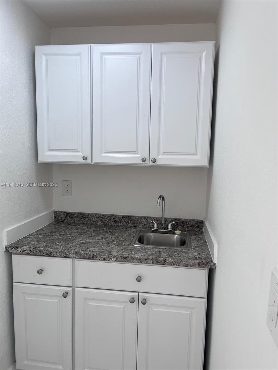50 Northwest 68th Court, Unit 3 Miami, FL 33126 - Photo 4 of 9 a kitchen with granite countertop white cabinets and a sink