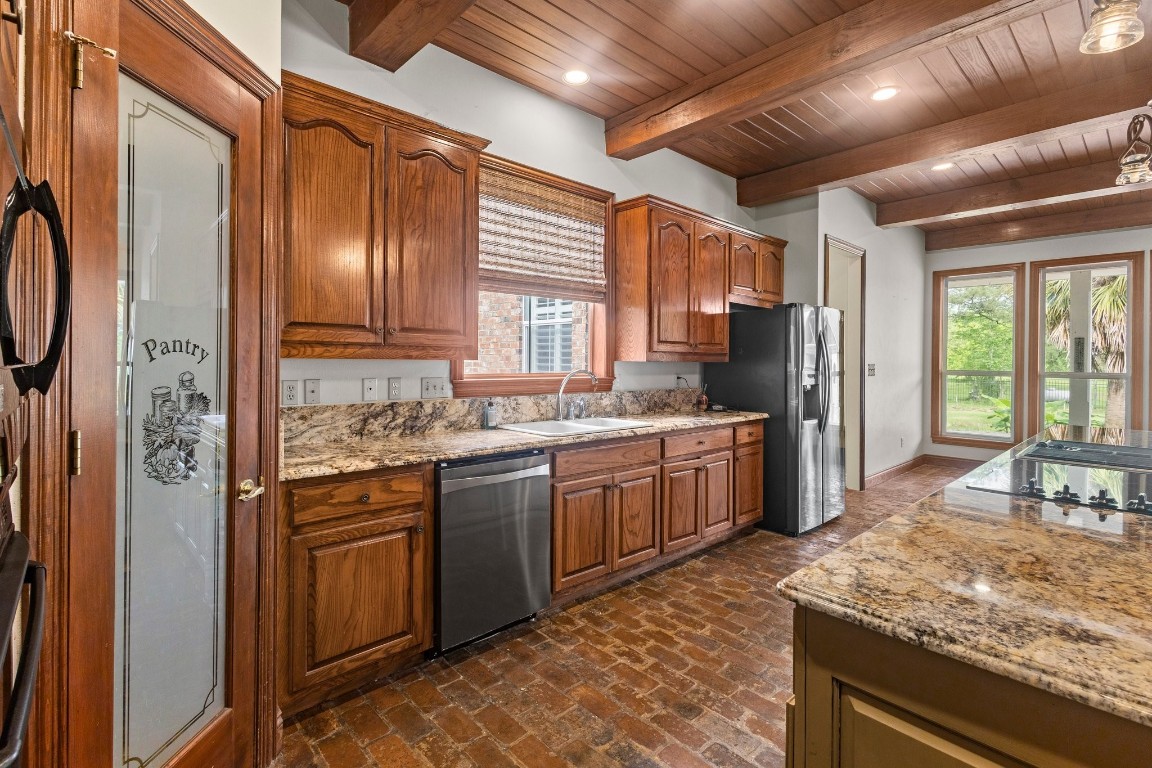 27076 Interstate 10 Winnie, TX 77665 - Photo 13 of 42 a kitchen with stainless steel appliances granite countertop a sink stove and refrigerator