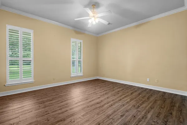 a view of an empty room with window and wooden floor