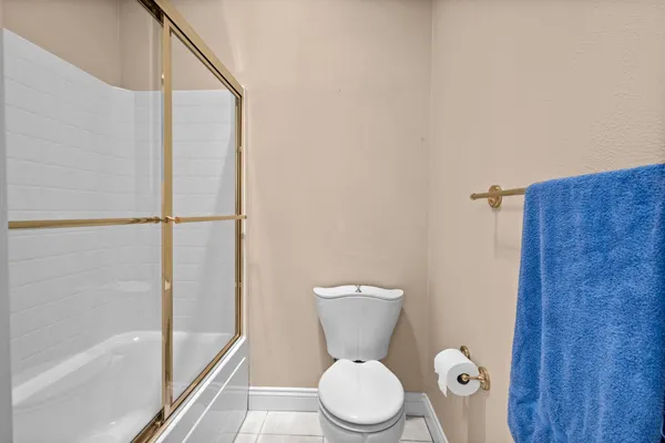 a white toilet sitting next to a bath tub