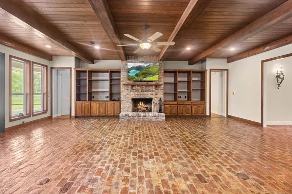 a view of an empty room with a fireplace and a window