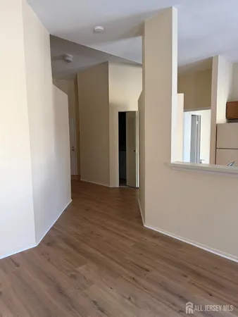 a view of a room with wooden floor and entryway