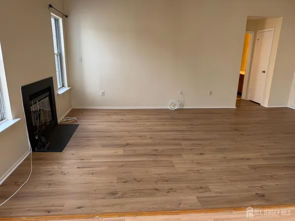 a view of a livingroom with an empty space wooden floor and fan