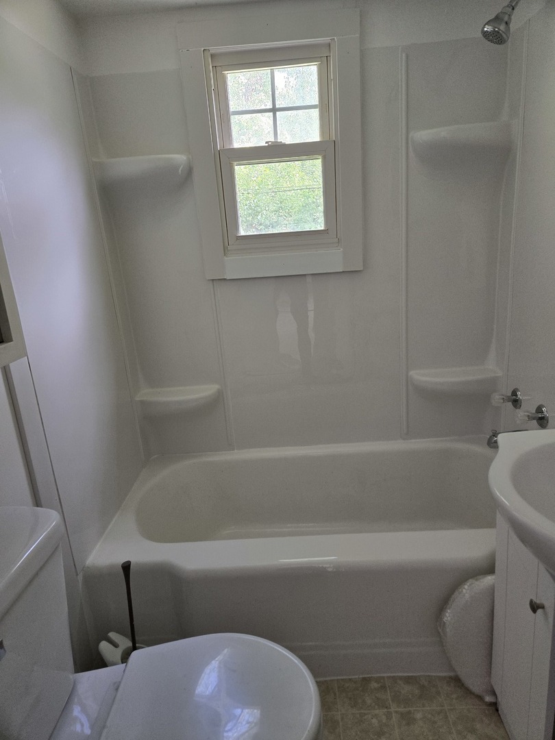26895 Bernice Street Wauconda, IL 60084 - Photo 7 of 16 a bathroom with a bathtub and window