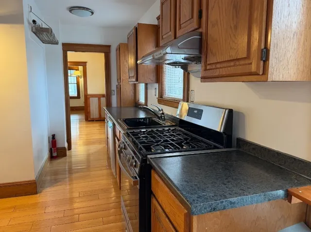 a kitchen with granite countertop a stove and a sink