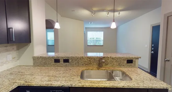 a bathroom with a granite countertop sink a mirror and shower