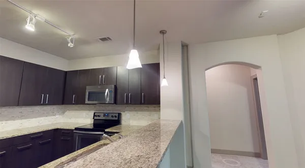 a kitchen with granite countertop a cabinets and steel appliances