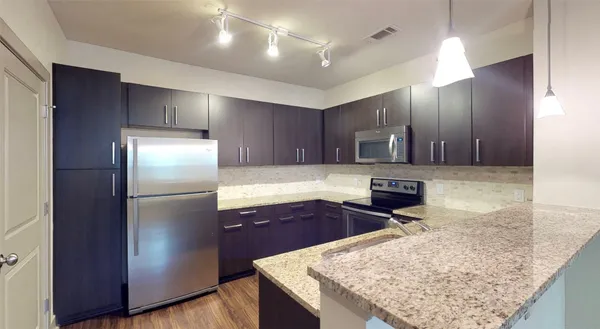 a kitchen with stainless steel appliances granite countertop a refrigerator and a sink
