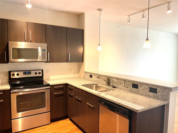 a kitchen with a sink a stove a microwave and wooden cabinets