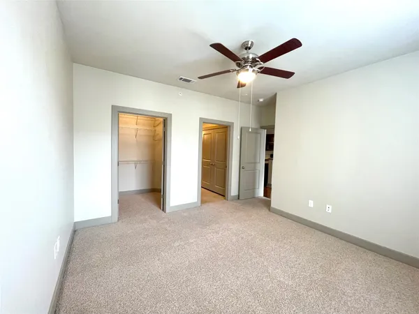 a view of an empty room with a ceiling fan