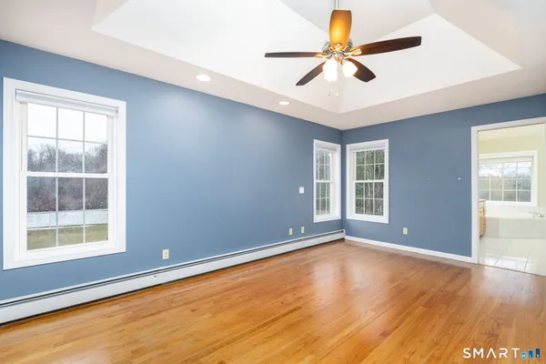 a view of an empty room with window and wooden floor