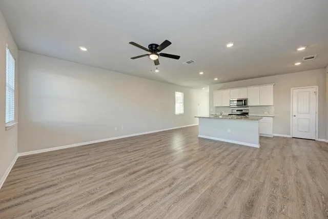 a large kitchen with a lot of counter space and a wooden floor