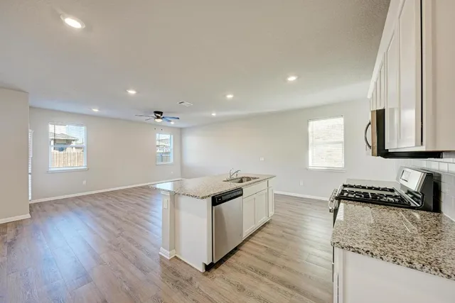 a kitchen with stainless steel appliances granite countertop a sink stove and refrigerator