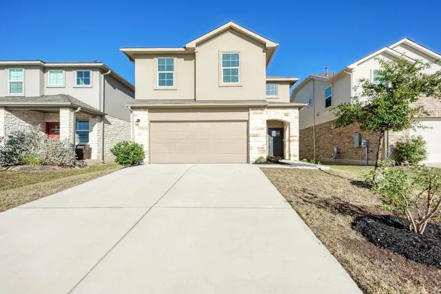 a front view of a house with a yard and garage