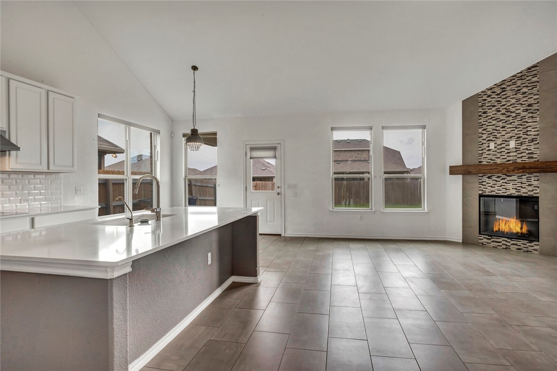 a large kitchen with kitchen island a sink stainless steel appliances and cabinets
