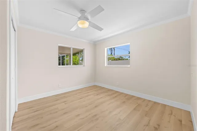 an empty room with windows and fan