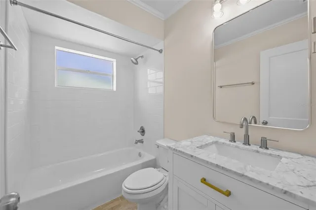 a bathroom with a granite countertop toilet a sink and a bathtub