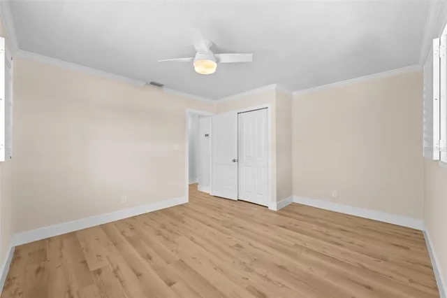 a view of an empty room with wooden floor