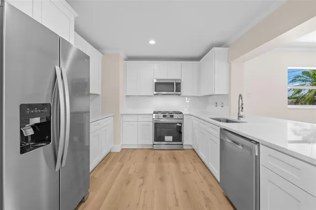 a kitchen with a refrigerator a sink and a stove top oven