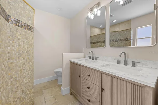 a bathroom with a granite countertop sink a toilet and a mirror