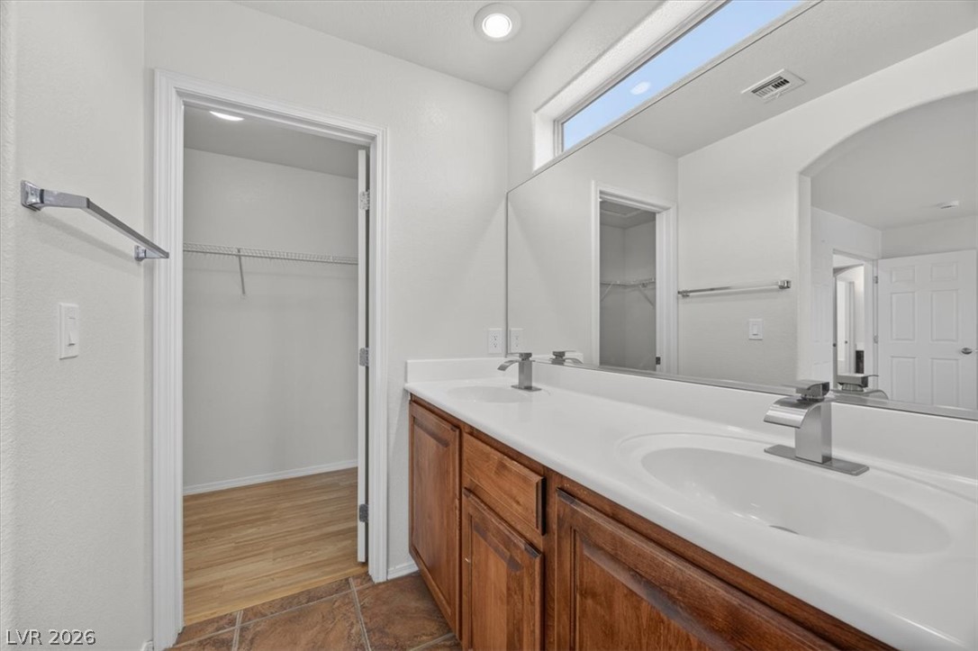 552 Albacate Street Henderson, NV 89015 - Photo 25 of 40 Double vanity with ample counter space and warm wood cabinetry awaits in this functional bathroom.