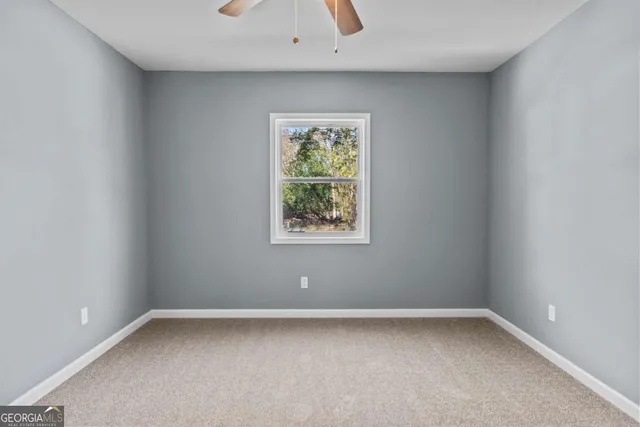 a view of a big room with wooden floor and windows