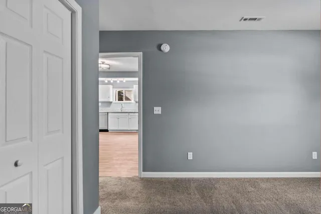 a view of an empty room with closet area