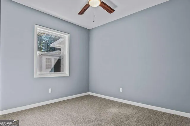 an empty room with a hallway and wooden door