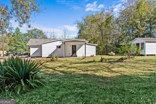 a front view of a house with a garden