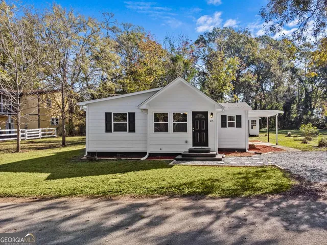 a view of a house with backyard and a tree
