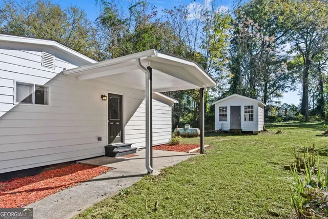 a view of an house with backyard and tree