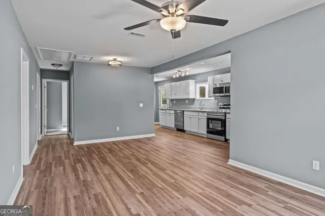 wooden floor in an empty room with a kitchen